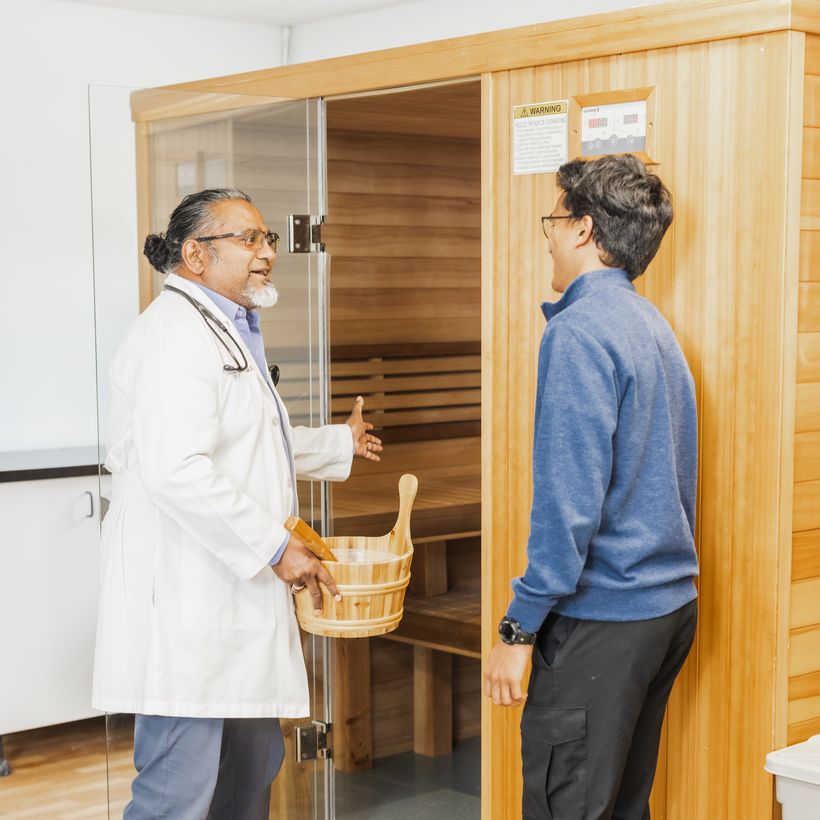 Dr. Vinod showing a patient the traditional sauna at Perpetual Health